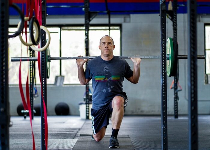 cross fit gym man kneeling with barbell